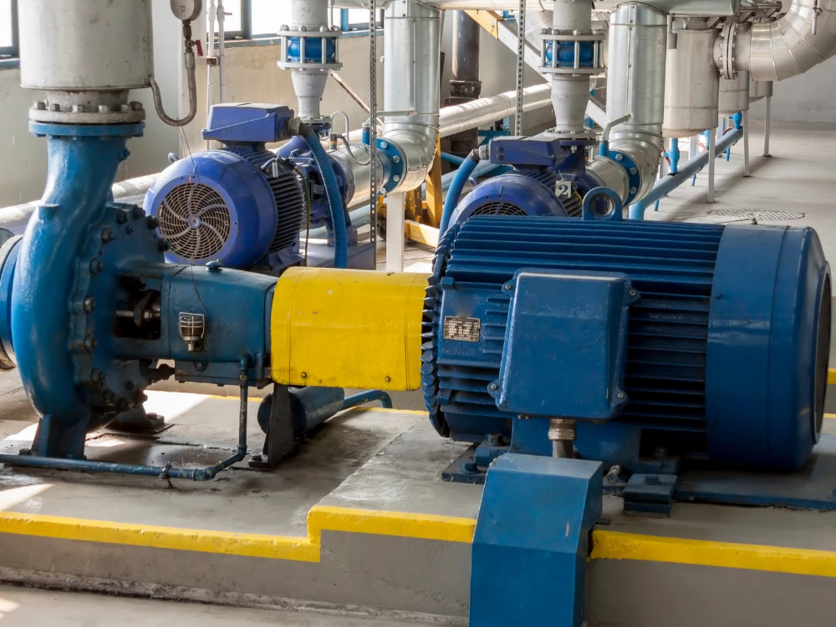 Industrial electric motor and centrifugal pump installation in a mechanical plant room.
