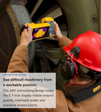Technician using a Fluke TiX580 to inspect a large industrial fan behind a safety guard