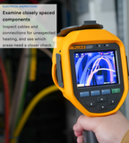 Handheld Fluke thermal camera displaying electrical cables; annotation describes inspecting closely spaced cables and connections for unexpected heating.
