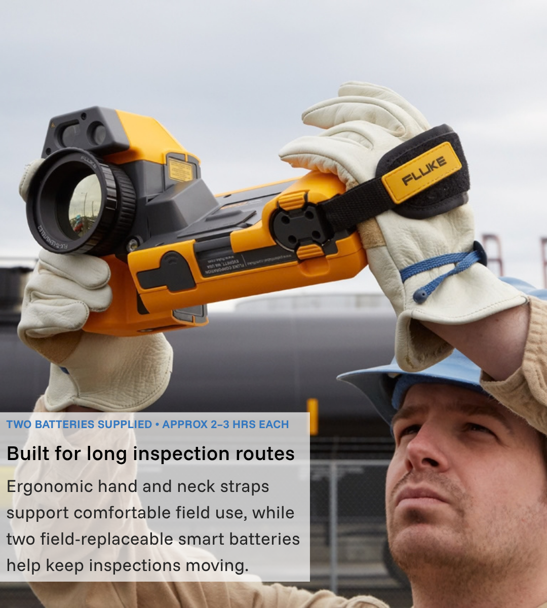 Technician holding a Fluke TiX501 overhead during an outdoor industrial inspection